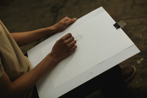 Person Holding White Illustration Board