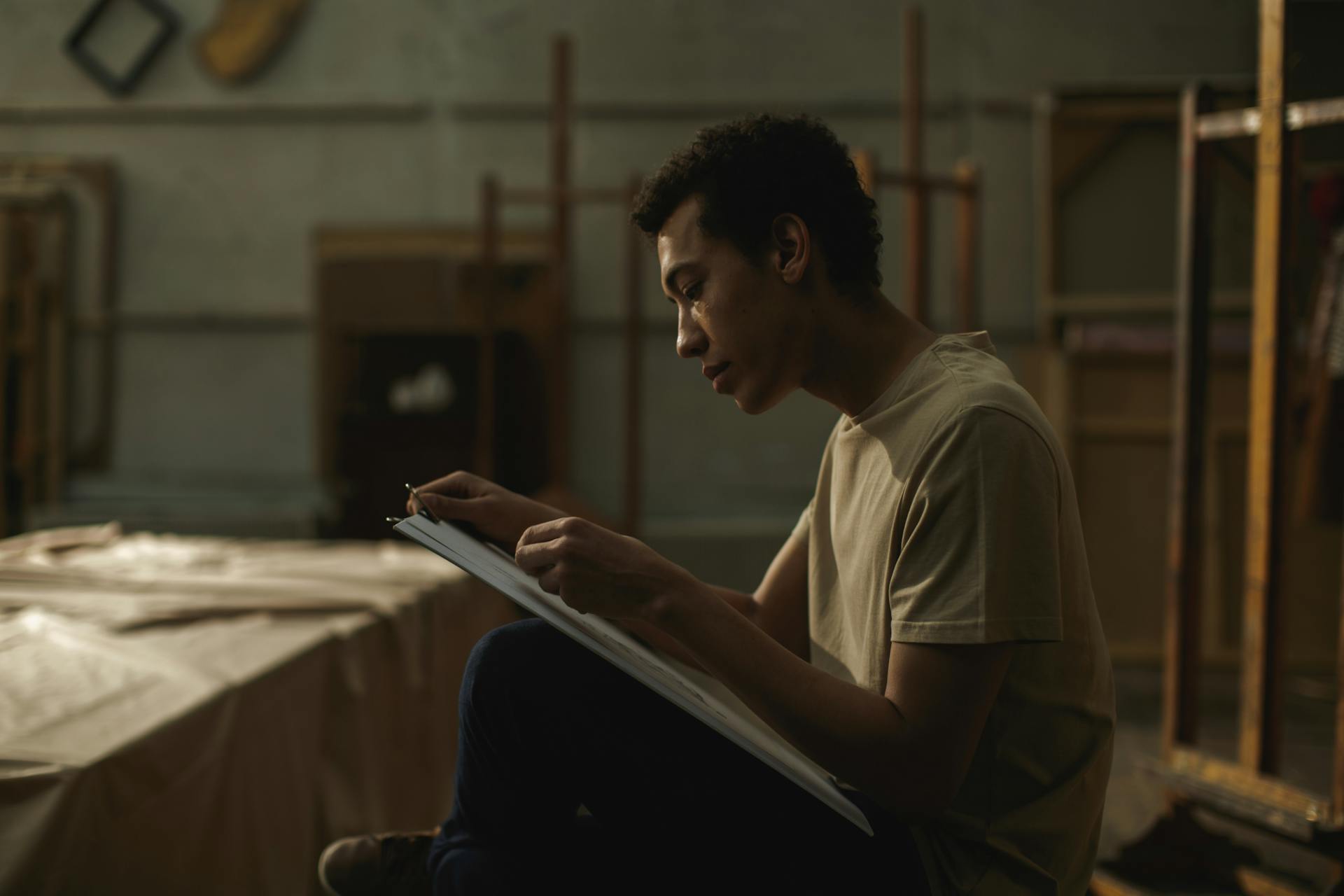 A Man Sketching On A White Cardboard