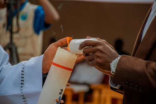 Free Close-up of two individuals lighting a candle together in a ceremony, symbolizing unity and tradition. Stock Photo