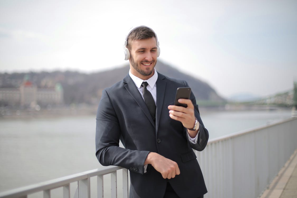 Man in Black Suit Jacket Holding Black Smartphone