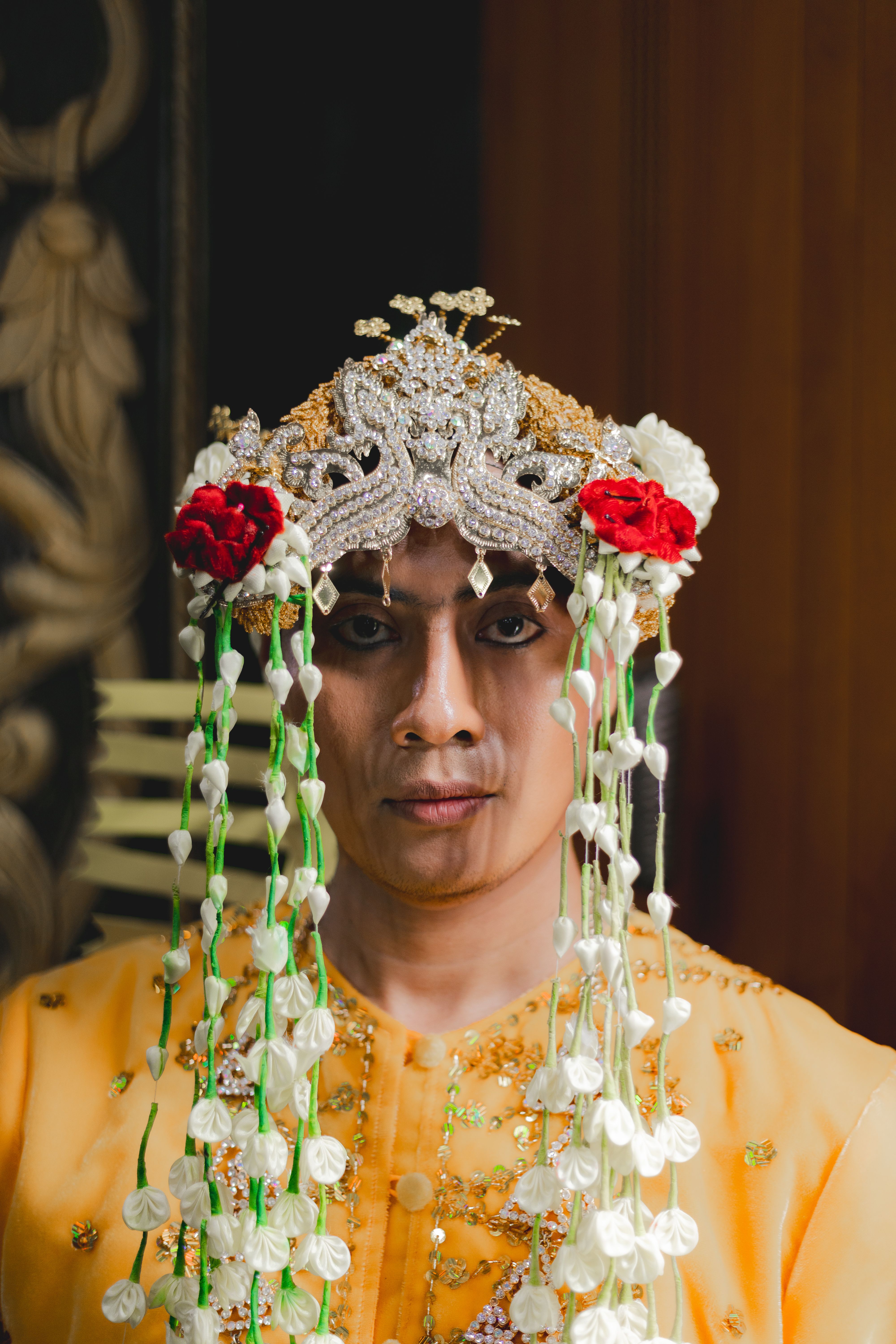 Portrait of an adult in traditional Indonesian wedding attire with intricate headpiece.