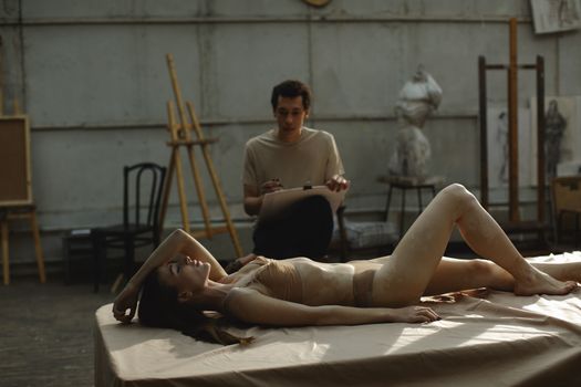 Man Holding Cardboard Near Woman Lying on Bed