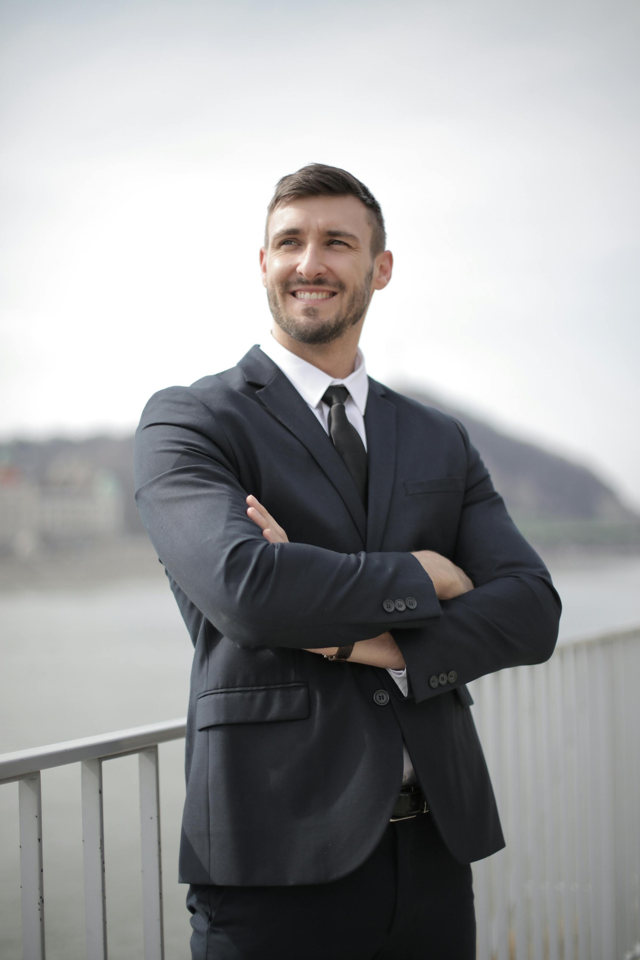 man in black suit jacket standing near railings