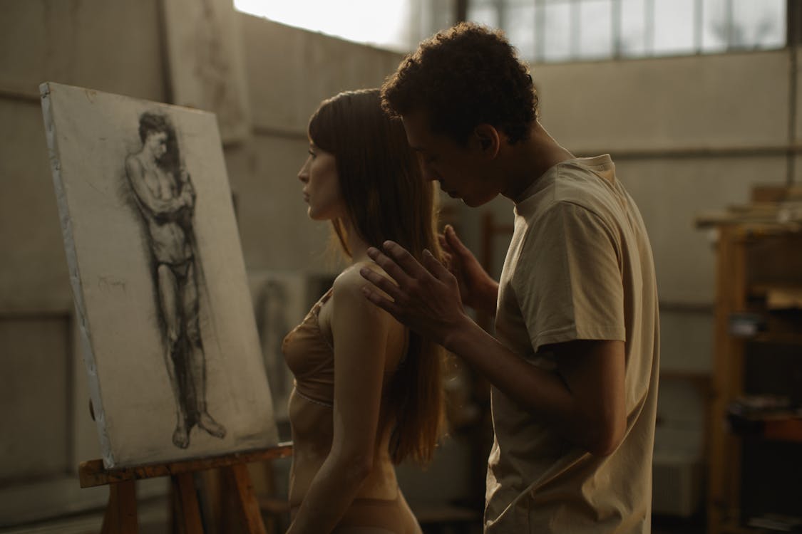 Man Caressing Woman Standing in Art Studio