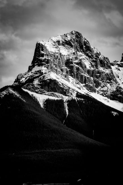 Striking black and white photo of a snow-capped mountain peak conveying drama and majesty.