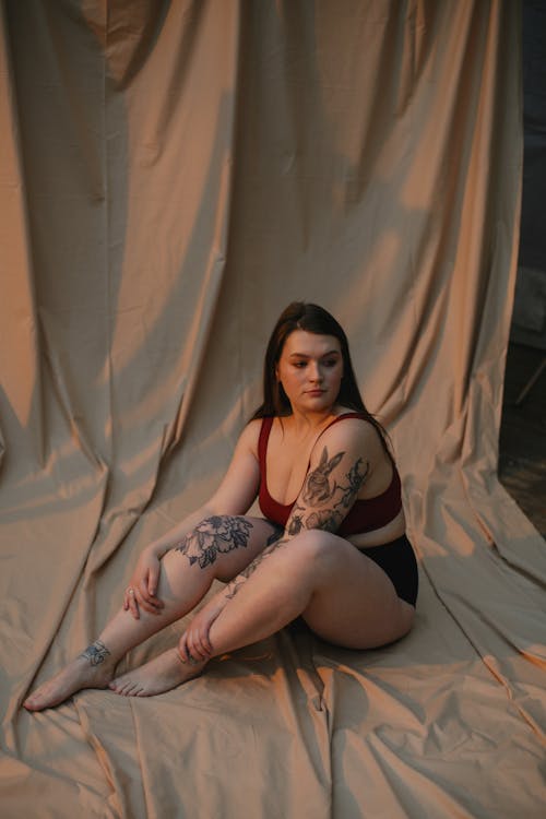 무료 갈색 담요에 앉아 빨간 브래지어에 여자 스톡 사진