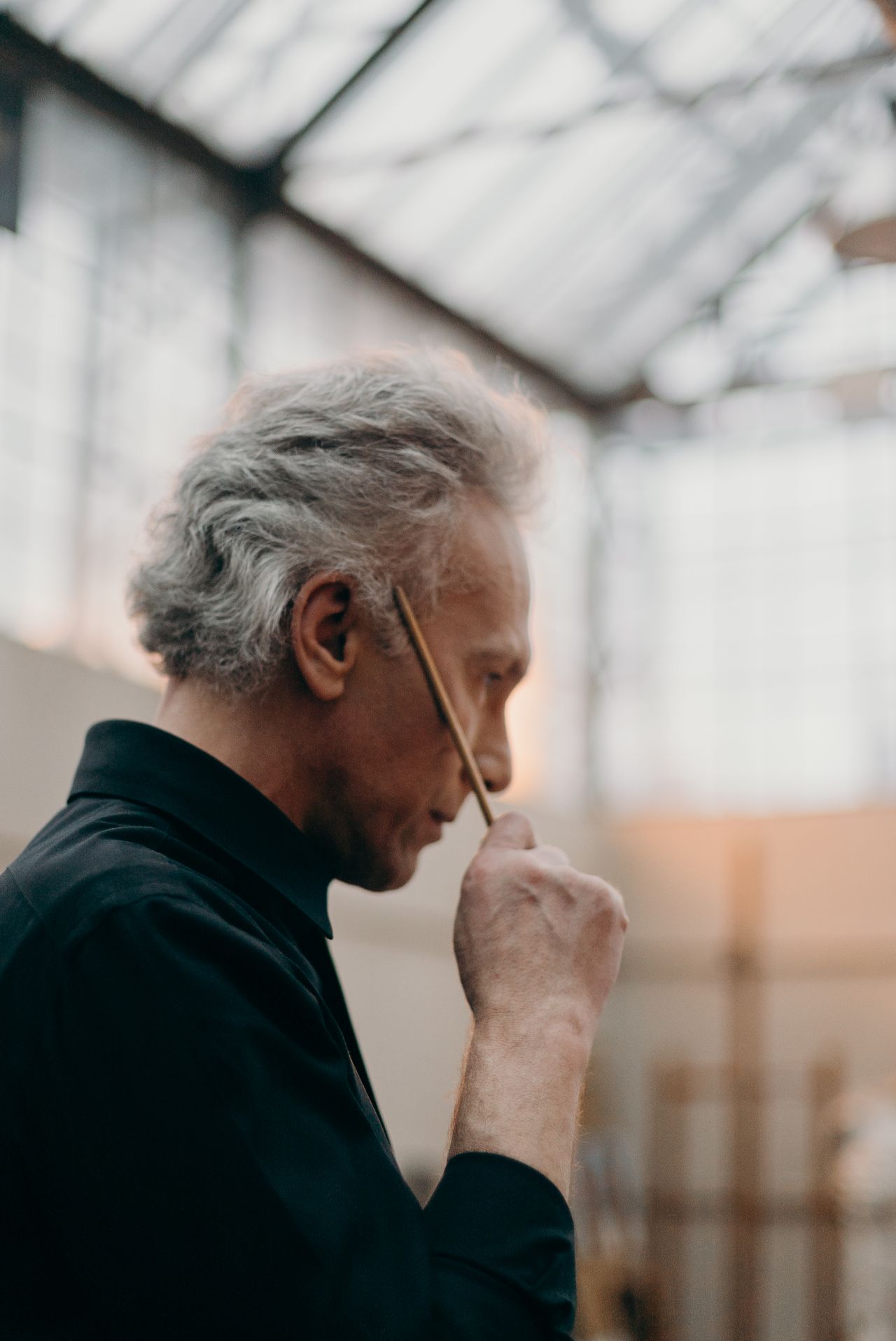 An artist standing back from their work, looking thoughtfully at his piece