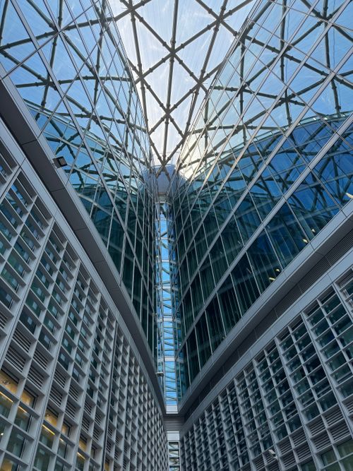 Free Upward view of modern glass architecture in Milan, showcasing intricate geometric patterns. Stock Photo