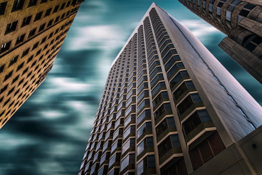 低角度镜头以引人注目的方式突出了旧金山现代摩天大楼在阴云密布的天空下的景象