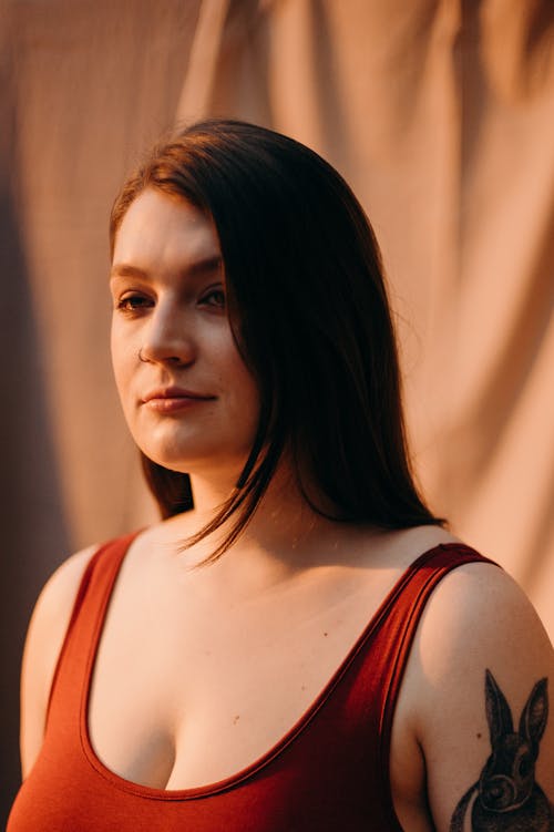 Женщина в красном топе с татуировкой