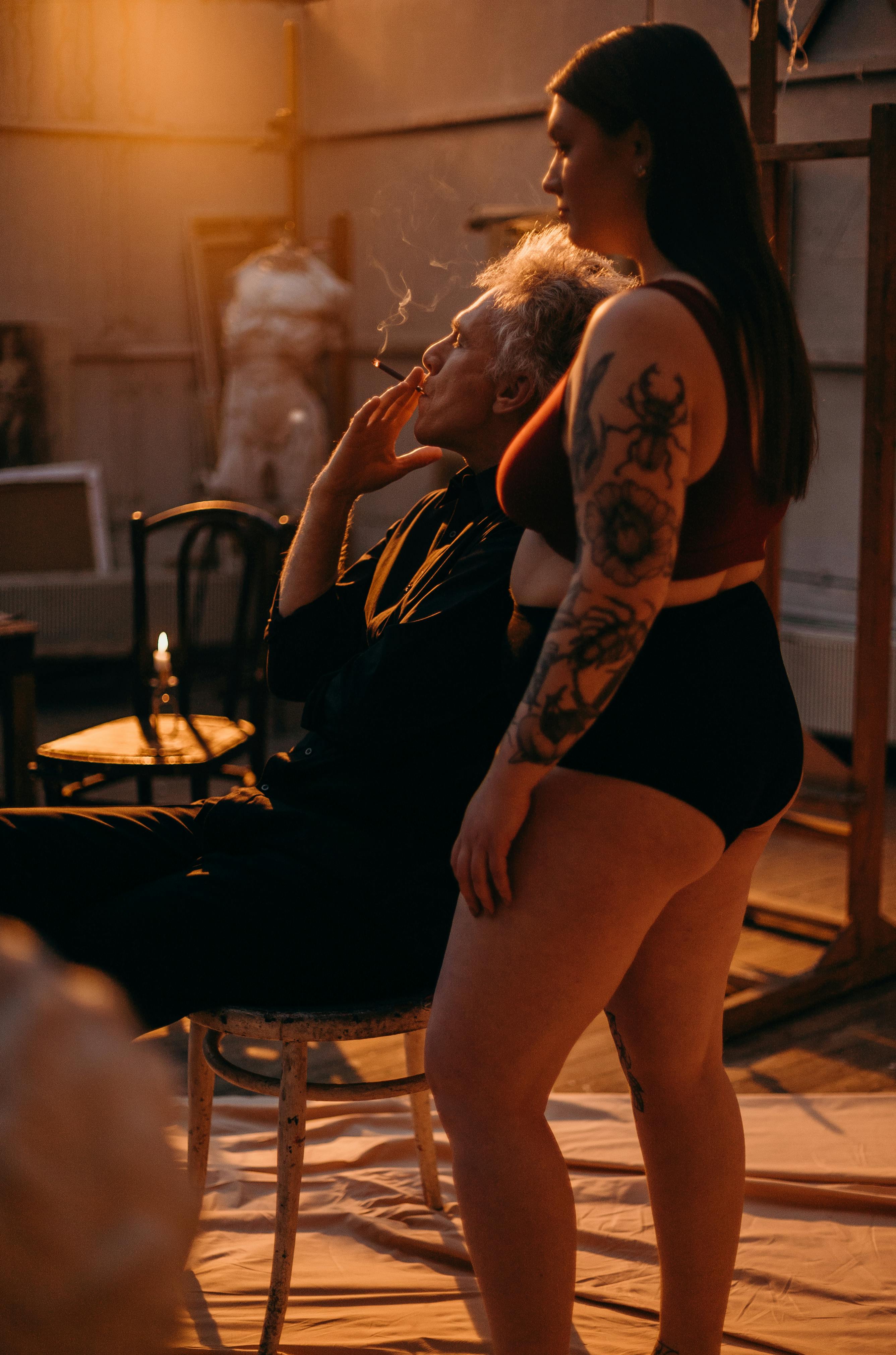 tattooed woman standing beside elderly man