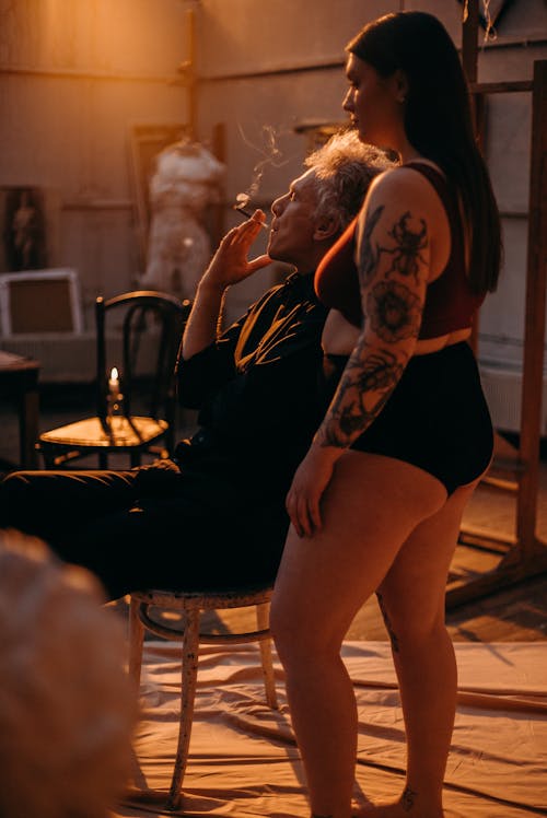 Woman with Tattoo Standing Beside Elderly Man