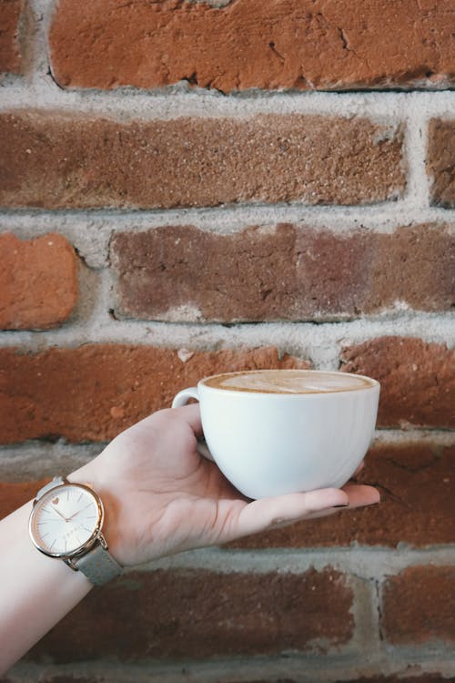 Person Holding White Ceramic Teacup