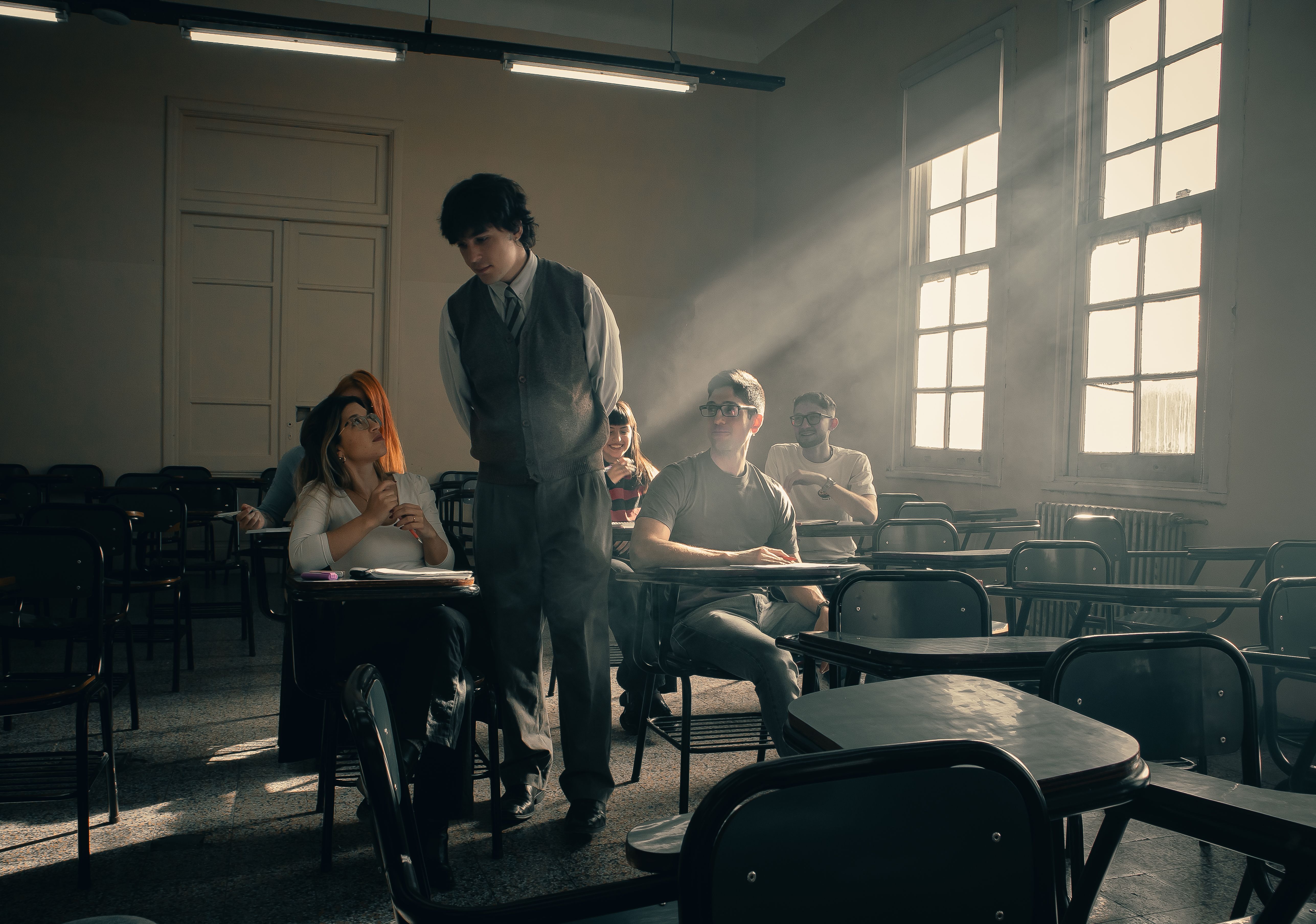Students engaged in a conversation in a sunlit classroom, fostering a warm academic atmosphere.