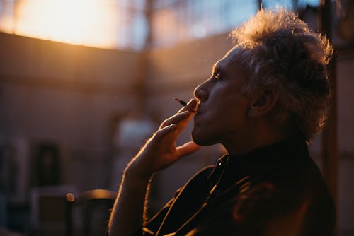 Side View Of A Man In Black Shirt Smoking Cigarette