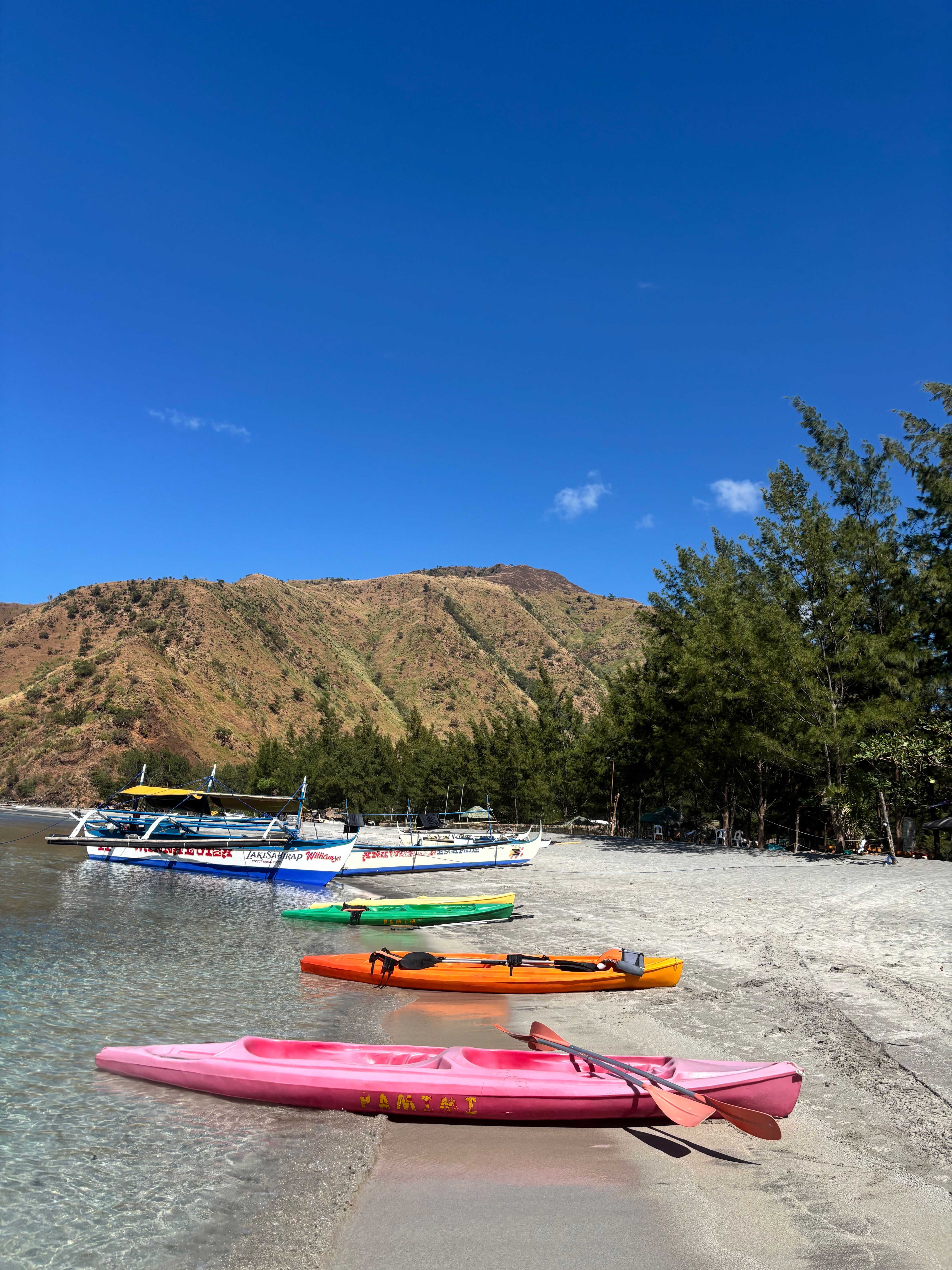 Colourful kayaks on a Zambales beach, ready for group activities