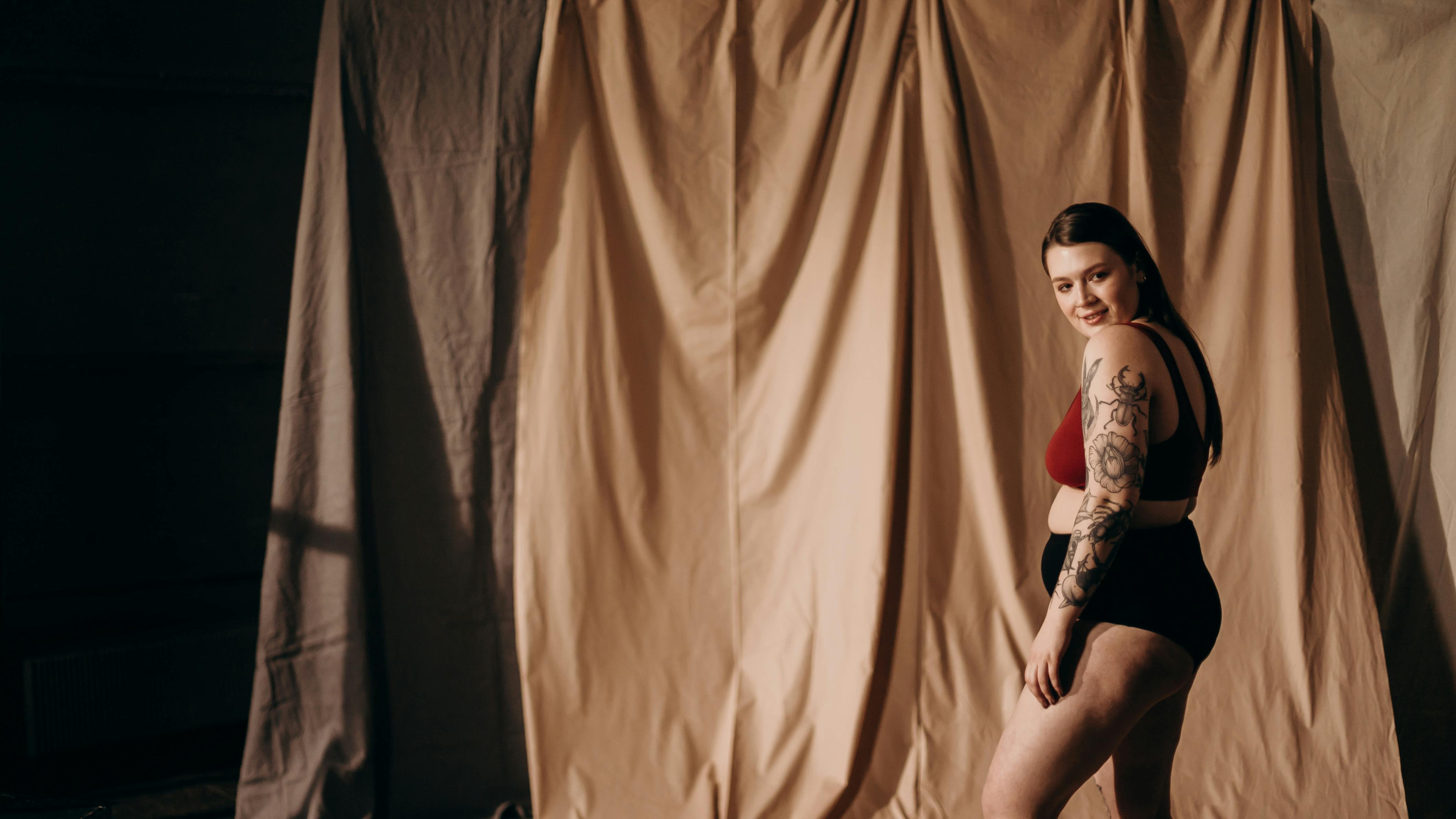 Gratis Pria Berkemeja Putih Dan Celana Pendek Hitam Duduk Di Tirai Coklat Foto Stok