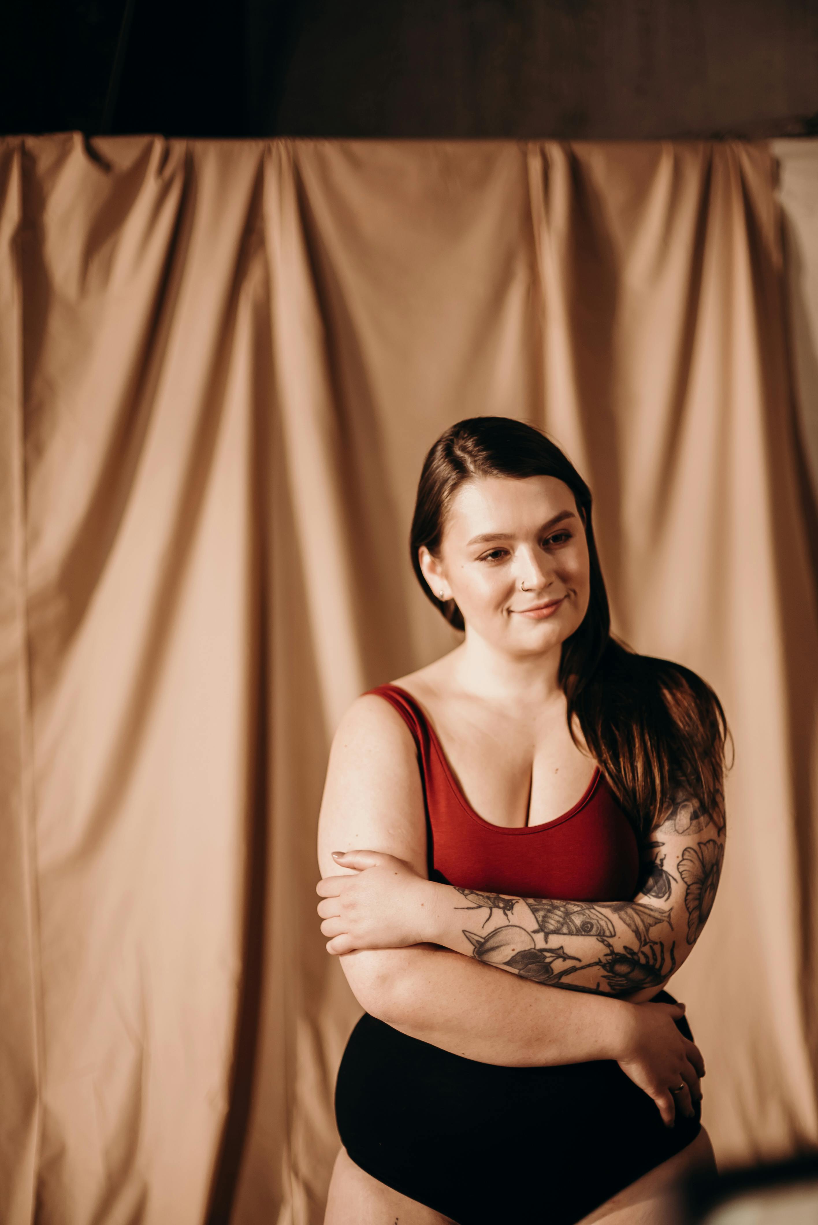 Woman in Red Sports Bra and Black Panty Standing Beside Brown Curtain ·  Free Stock Photo