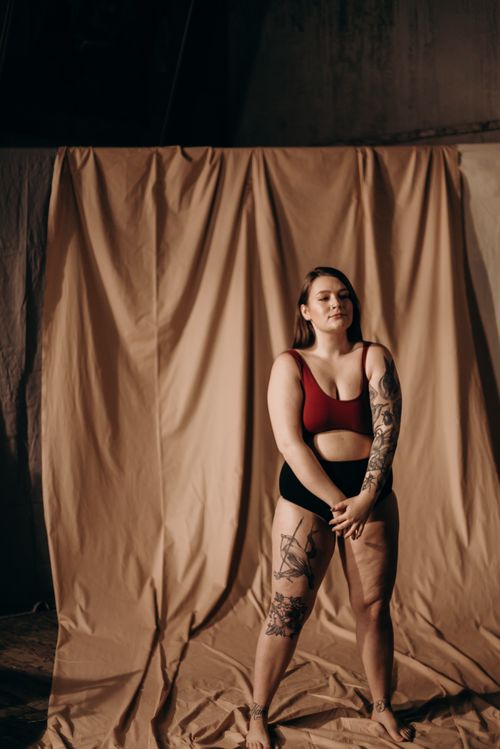 Free A tattooed woman confidently poses indoors, showcasing her body art. Stock Photo