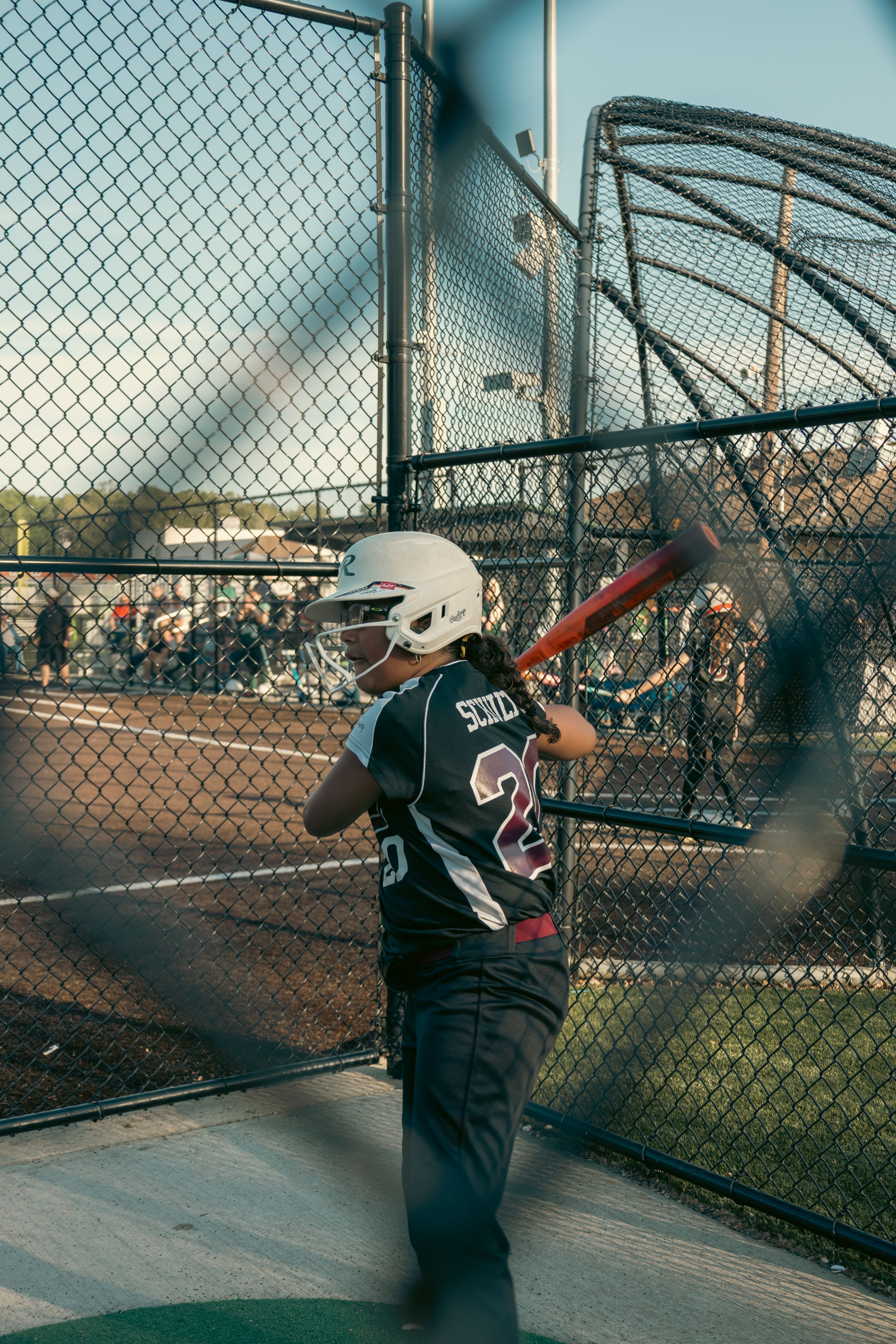 Young Softball Player at Bat in Outdoor Cage · Free Stock Photo