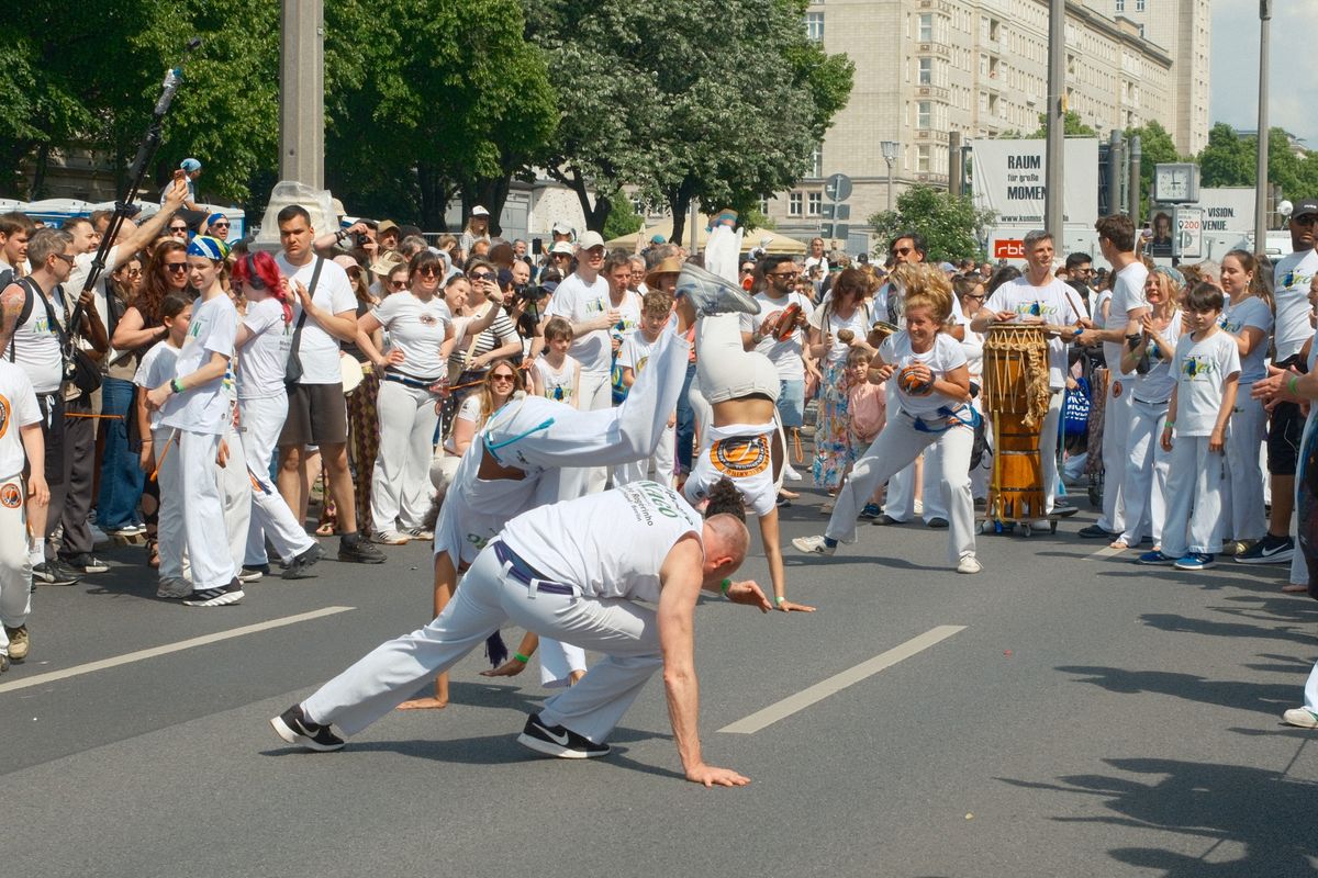 Un grupo grande de capoeira se presenta en la calle frente al público
