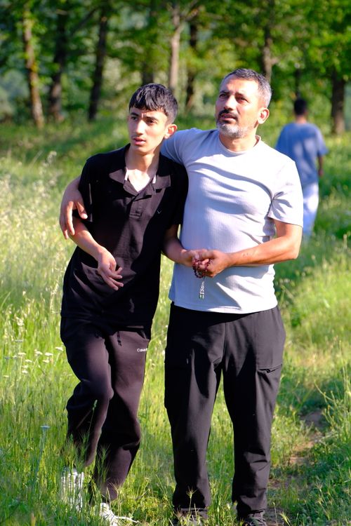 Free A father and son walking together outdoors in a lush green meadow in Keles, Bursa, Turkey, enjoying a sunny day. Stock Photo