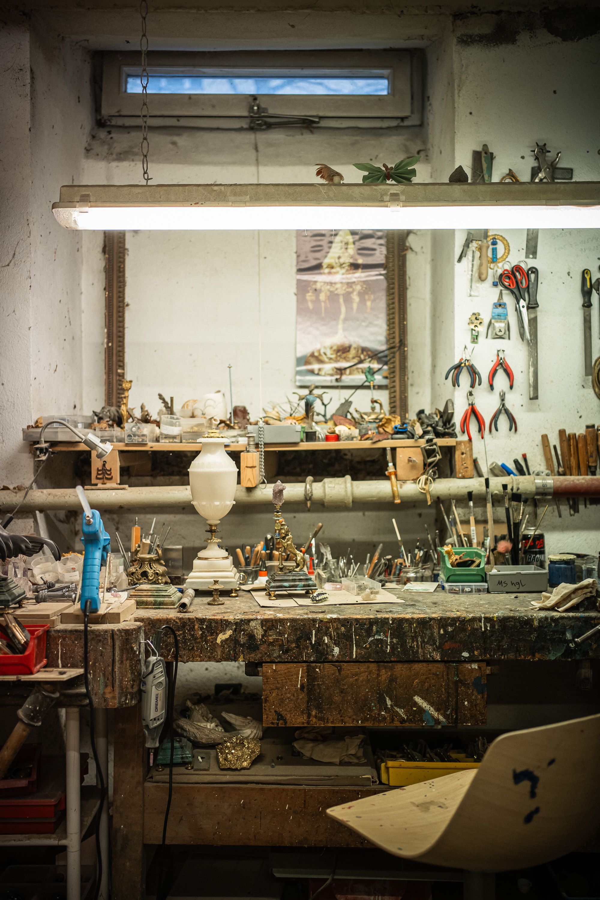 A detailed view of a cluttered artisan workbench in a Berlin workshop with tools and crafts.