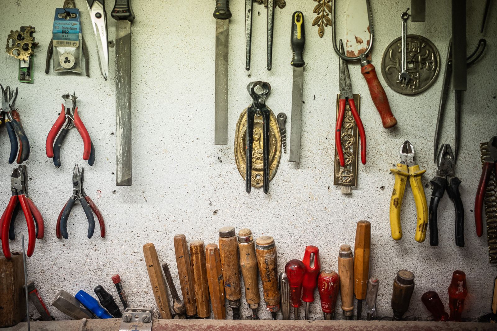 Assorted hammers, pliers, screwdrivers, chisels and hand tools organized in a workshop