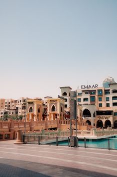 View of a modern architectural complex with the Emaar sign in Dubai under a clear sky.