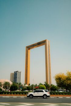 The Dubai Frame stands tall in a vibrant cityscape with clear skies, offering a modern architectural marvel.