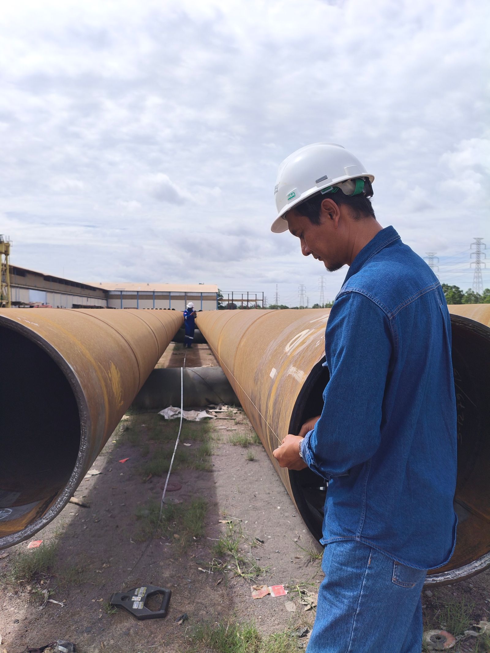 Field personnel inspecting industrial pipeline work