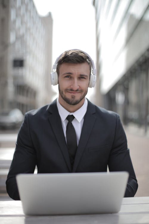 Man in Black Suit Jacket Wearing White Headphones