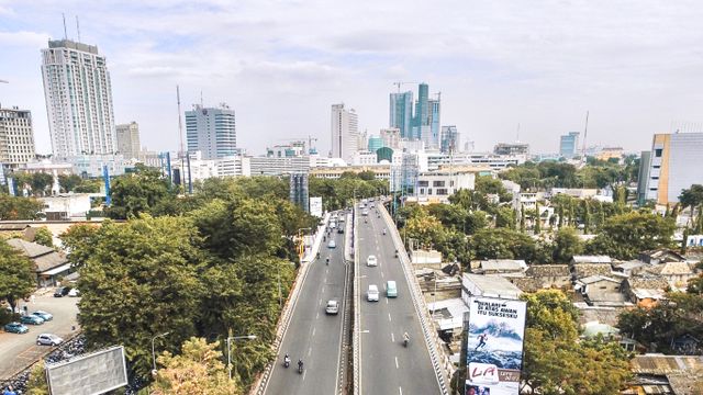 Aerial shot of Surabaya cityscape showcasing roads, buildings, and greenery. — lounges at Surabaya Airport