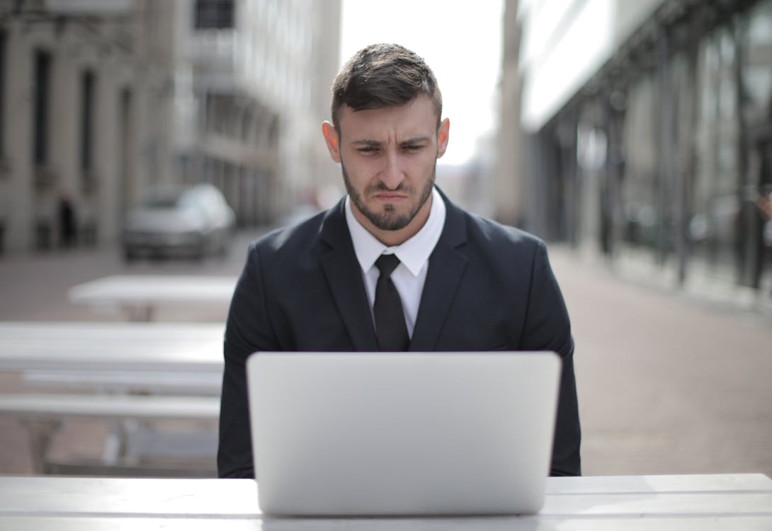 Man in Black Suit Jacket Using Computer Laptop