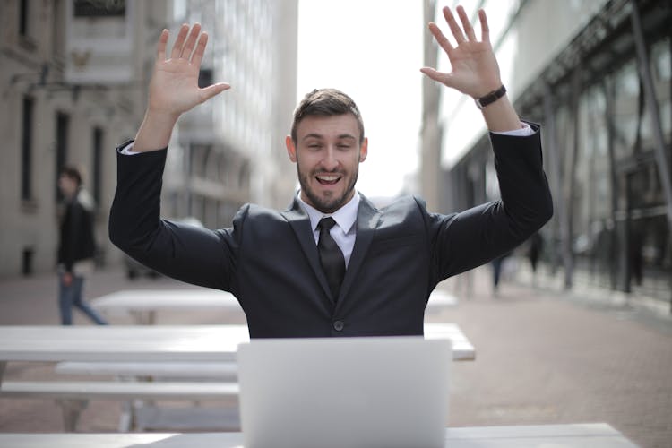 Man In Black Suit Raising Both Hands