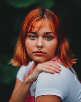 A striking portrait of a redheaded woman with a nose ring, emphasizing her distinct features and piercing gaze.