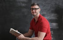 Man in Red Polo Shirt Holding a Book