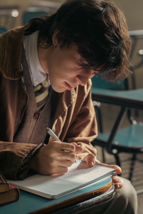 Free University student writing in a classroom in Buenos Aires, Argentina, with intense focus and concentration. Stock Photo
