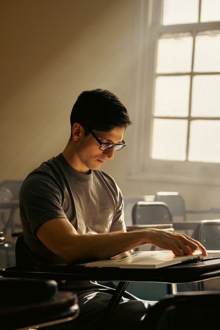 A focused university student reads in a sunlit classroom in Buenos Aires. A focused university student reads in a sunlit classroom in Buenos Aires.