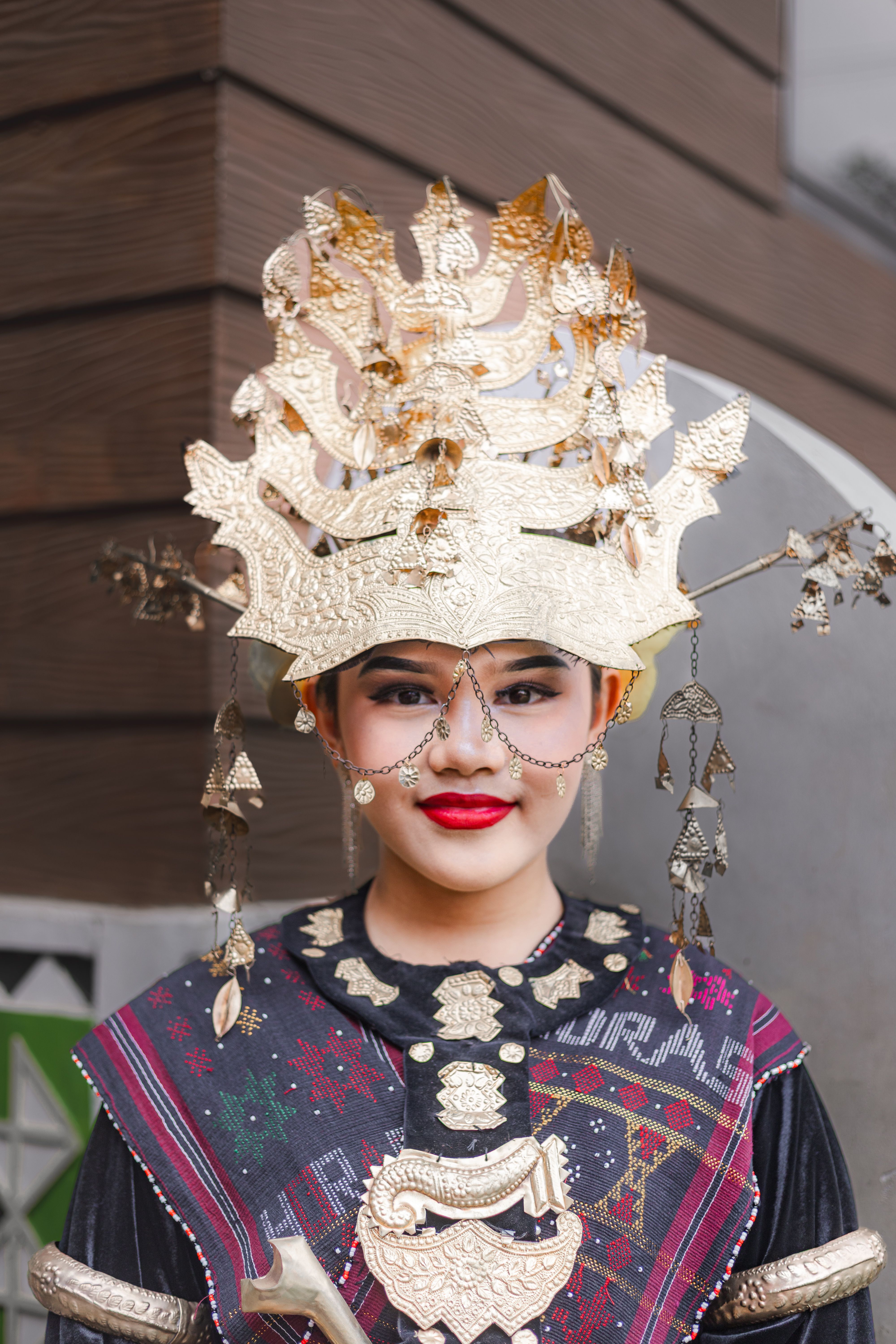 A woman in traditional Balinese attire with a detailed golden headdress showcasing cultural heritage.