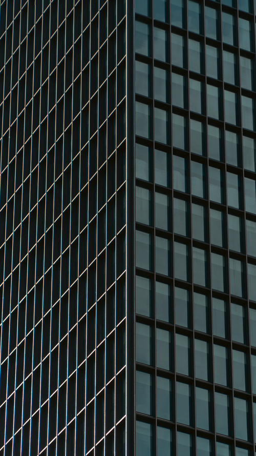 Free Detailed view of a modern skyscraper with reflective glass windows. Stock Photo