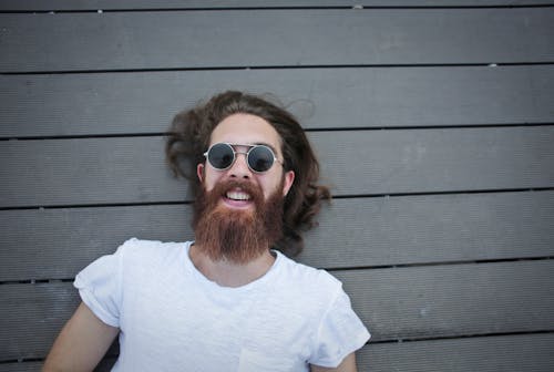 A Joyous Man Lying on a Wooden Floor