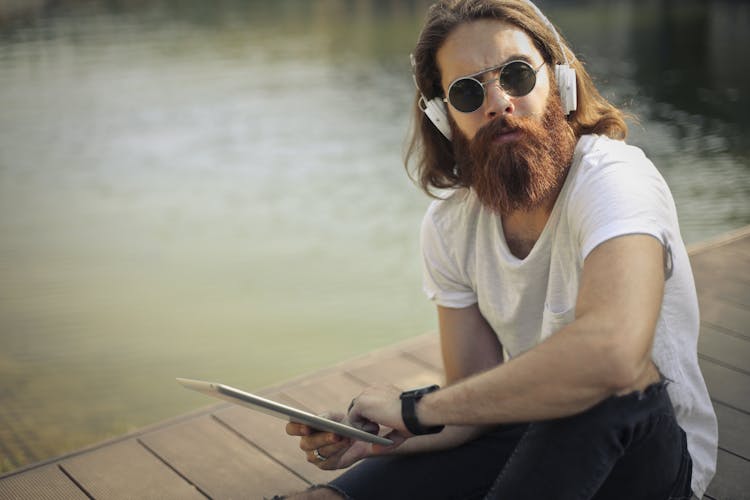 Man In White Crew Neck T-shirt And Black Pants Listening Music