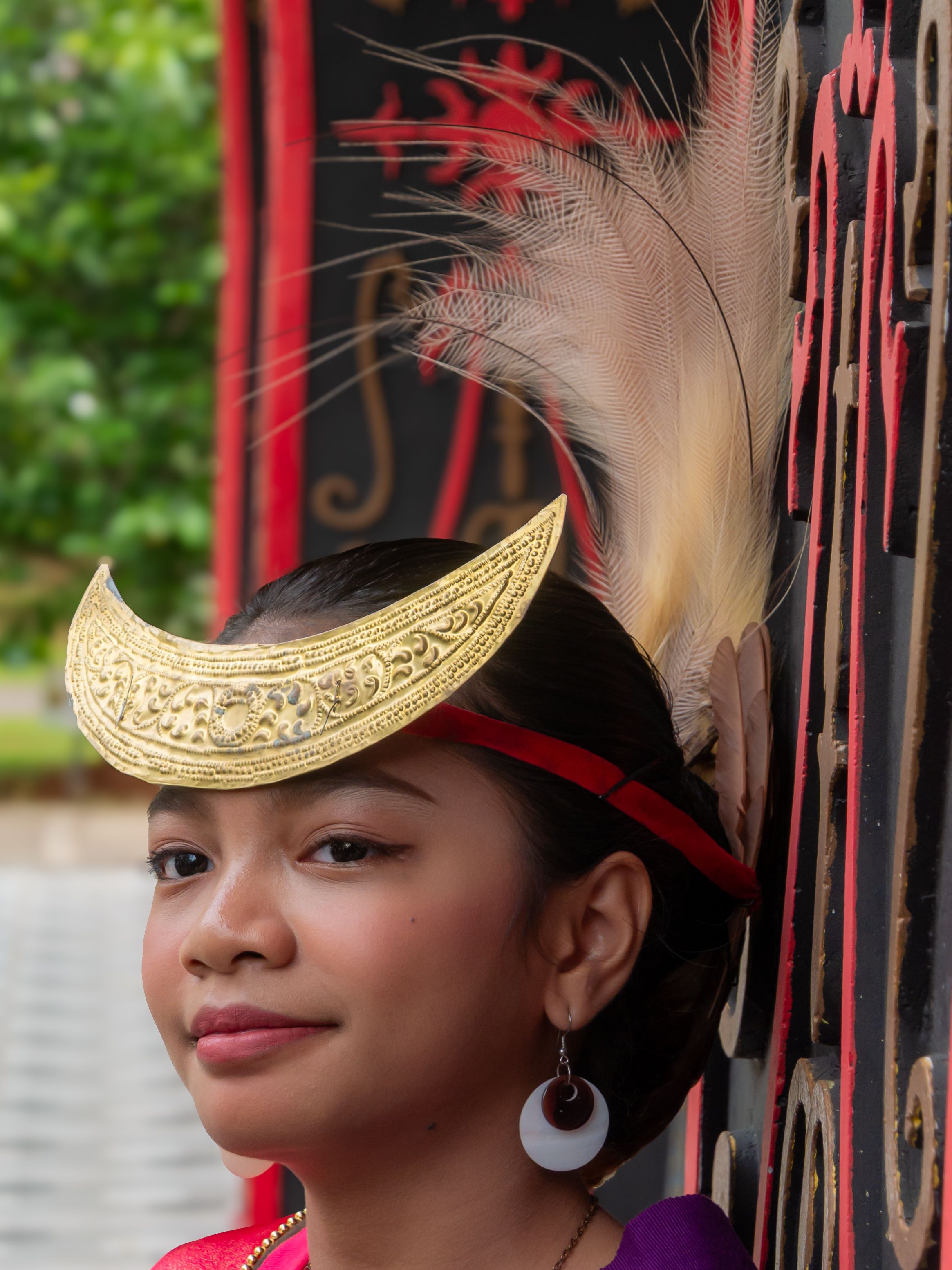 Portrait of a young woman wearing traditional cultural costume with ornate headdress and intricate designs.