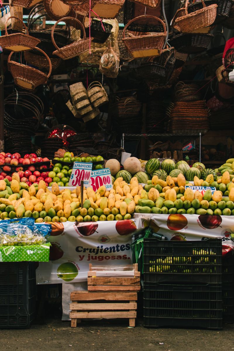 Colorful display of fruits at a bustling Mexico City market in summer.