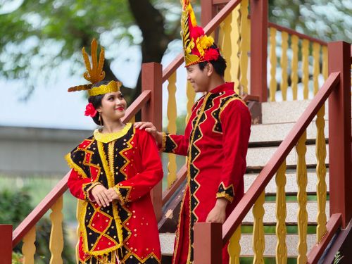 Free A couple in vibrant traditional Indonesian costumes posing outdoors, showcasing cultural heritage. Stock Photo