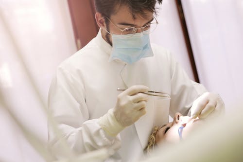 Homme En Chemise à Manches Longues Blanche Tenant Un Outil Dentaire