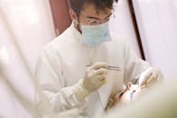 在牙科诊所里，一名戴着口罩和手套的牙医正在为患者治疗