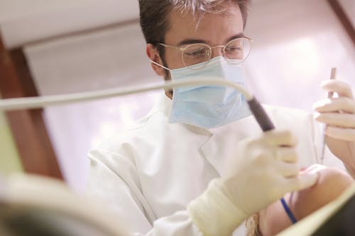 Man in White Dress Shirt Holding Dental Tools