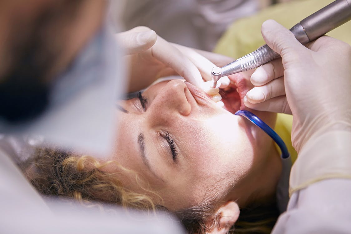 Free Woman's Teeth Being Clean By Dentist Stock Photo